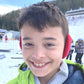 Young boy in ski location wearing red Snugga-Lugs
