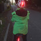 Rear view of a cyclist showing trixski LED Light in use on a cycling helmet and below the  saddle 