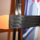 Close up of orange silicone puller tab on trixski Ski Carrier webbing strap