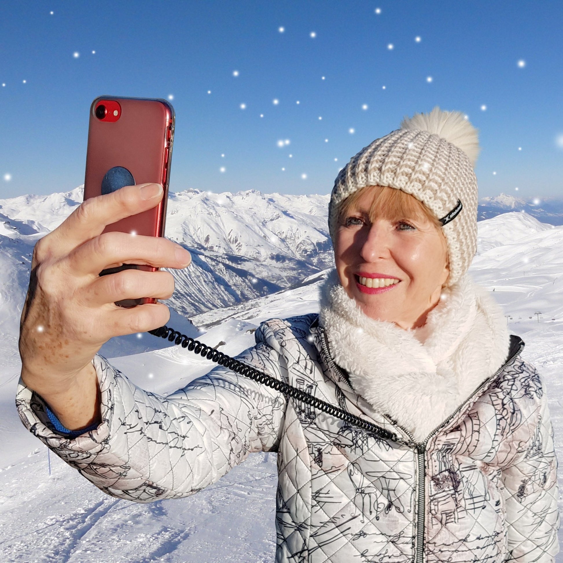 Snowy mountain location showing front view of trixski PhoneSafe in use when attached to the zip of a ski jacket