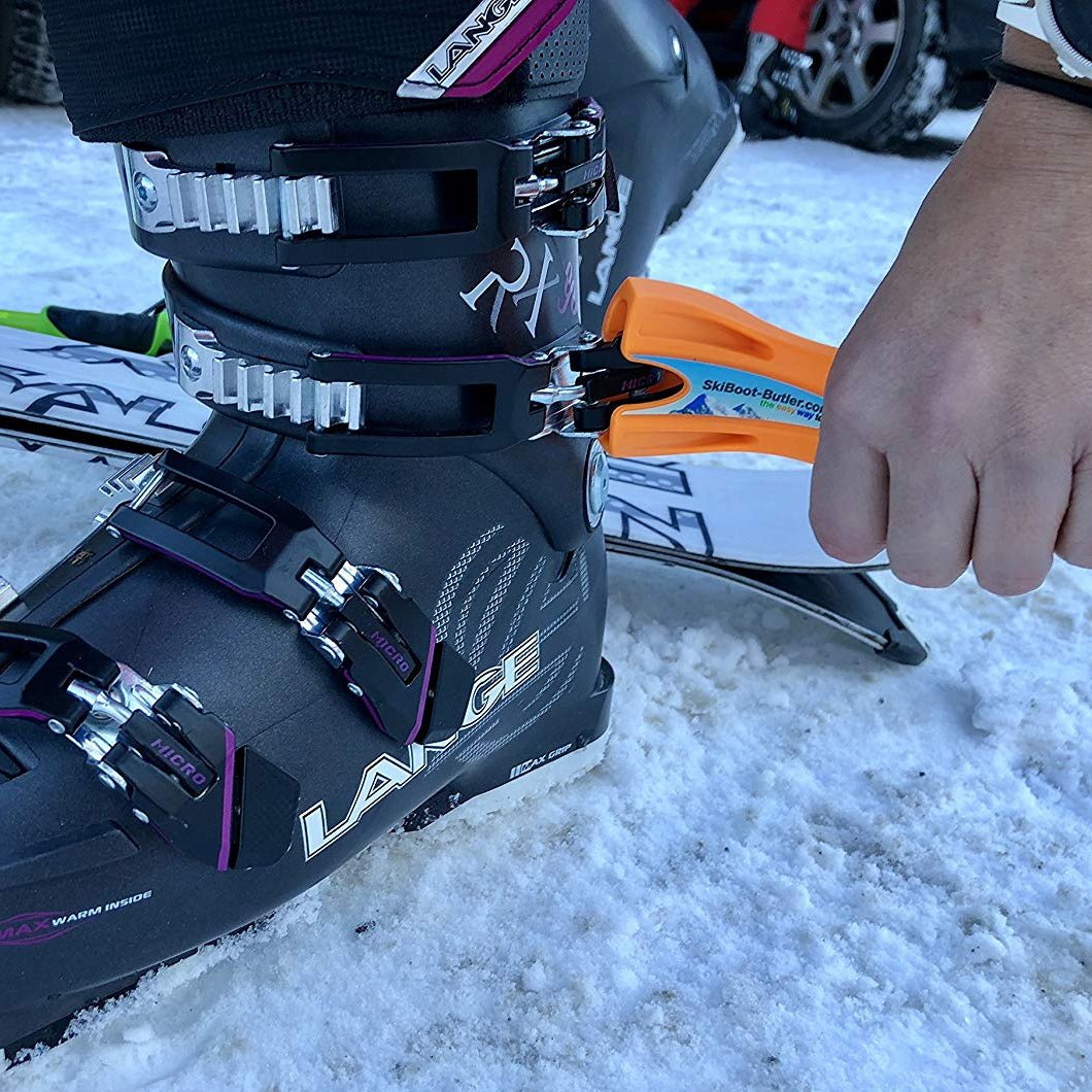 Orange option of ski boot buckle lever in use on a boot clip on snow